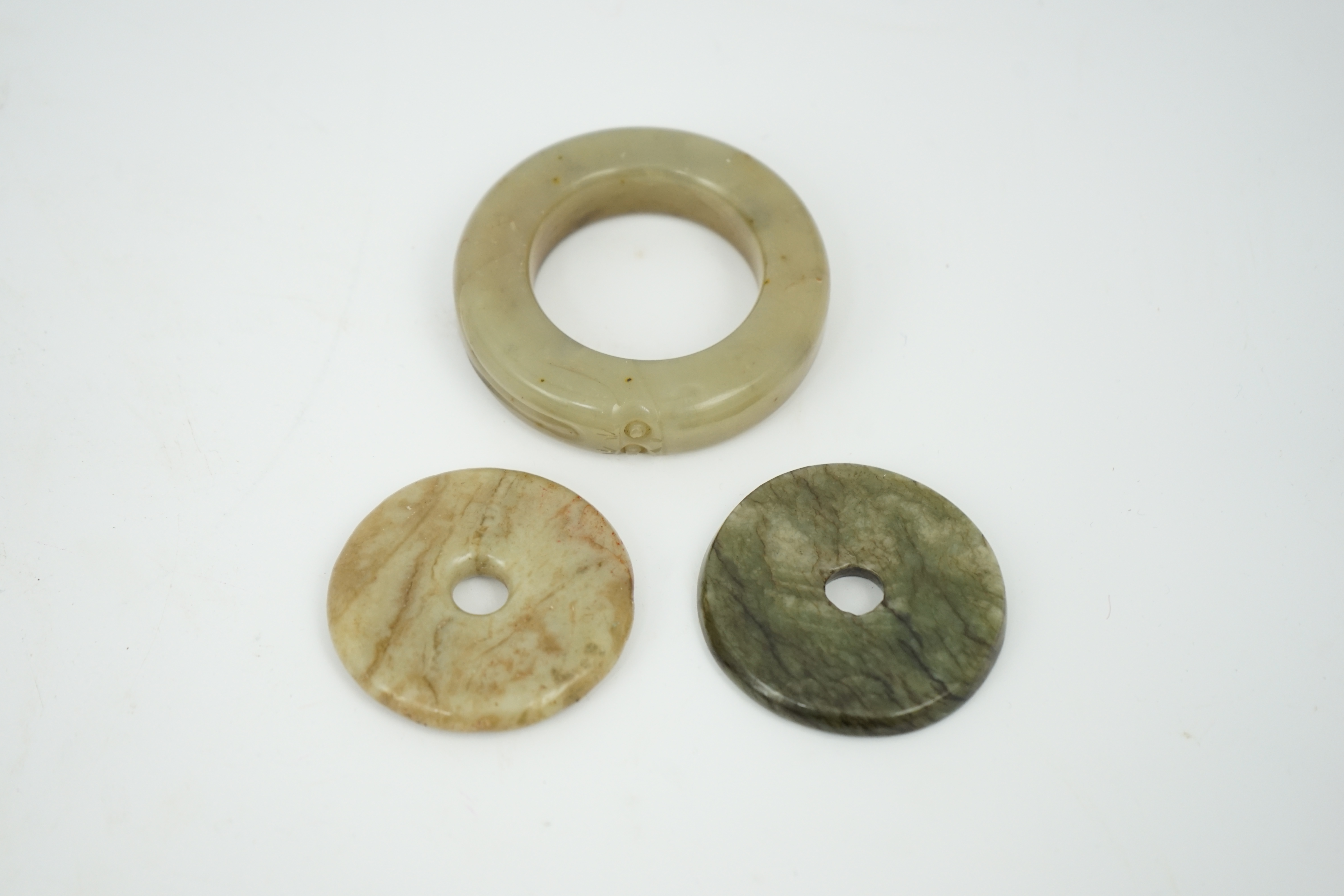 Two Chinese soapstone bi discs, and a jade ring, 18th century or earlier, largest 6.5cm in diameter. Condition - good